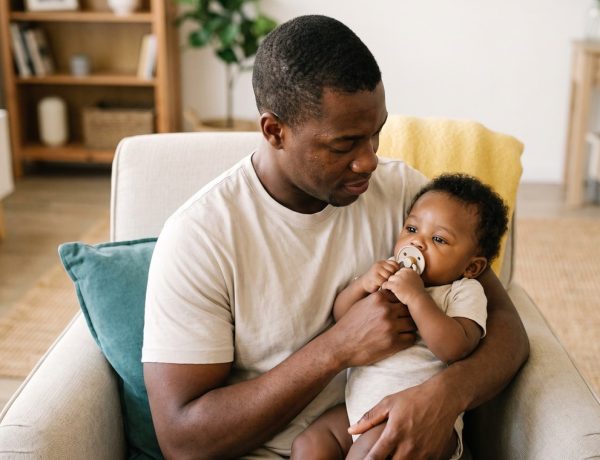 Bebê tranquilo sugando a chupeta no colo da mãe, dúvida comum entre chupeta ou dedo do bebê