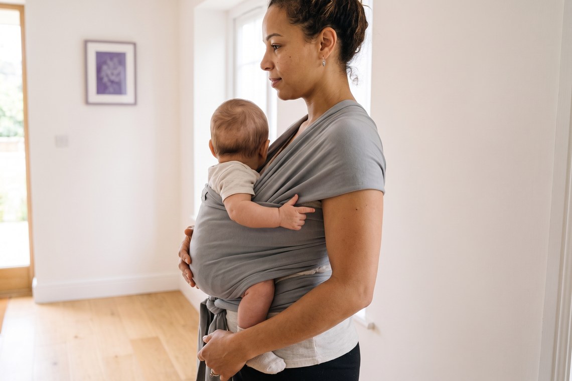 Posição correta    do quadril do bebê no sling, com joelhos mais altos que o bumbum