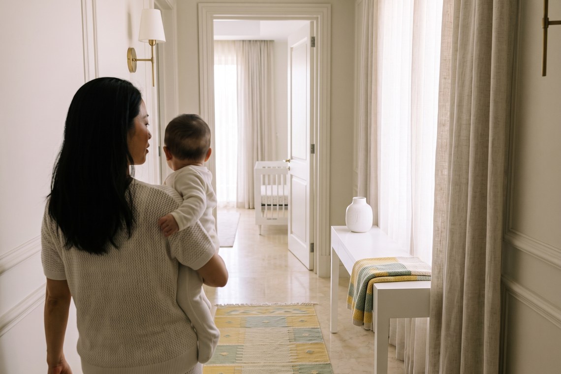 Mãe levando o bebê ao berço do próprio quarto na transição do sono